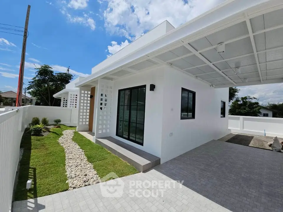 Modern white house exterior with carport and landscaped garden