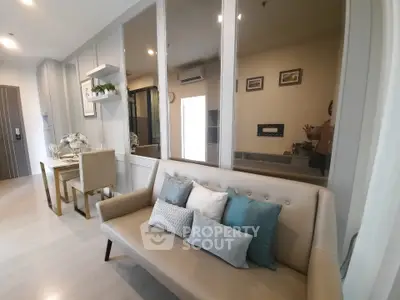 Modern living room with elegant decor and dining area, featuring a stylish sofa and wall mirrors.