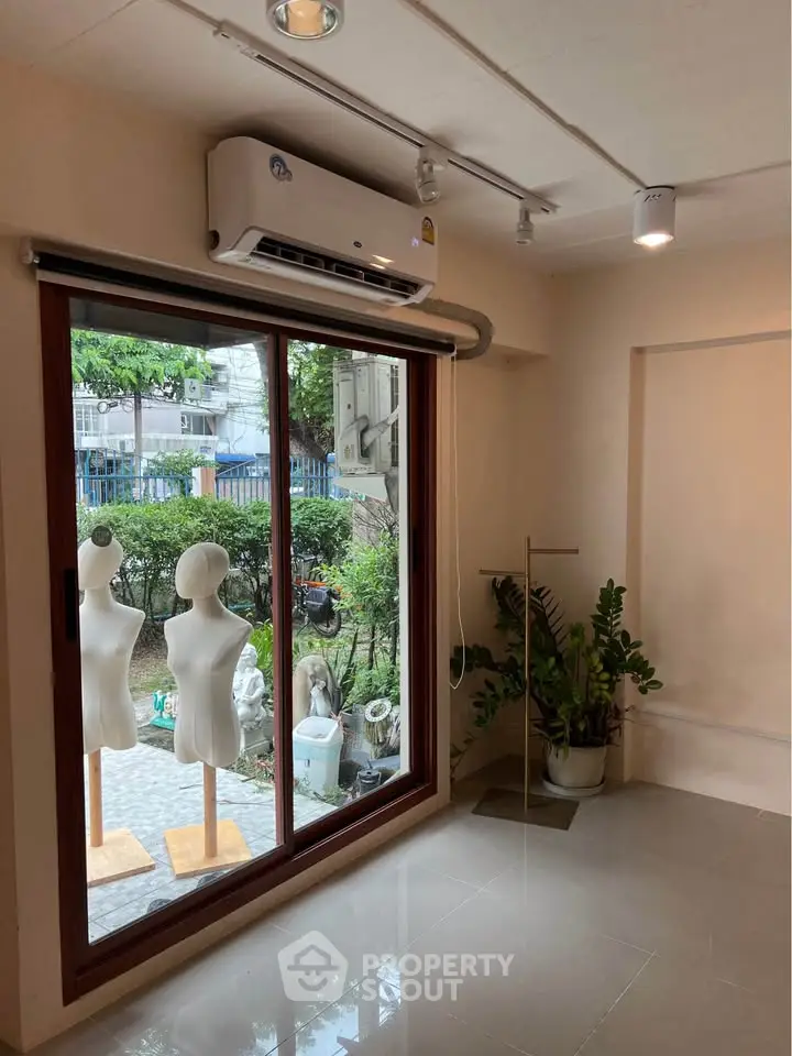 Spacious room with large window and air conditioning, ideal for creative workspace or studio.