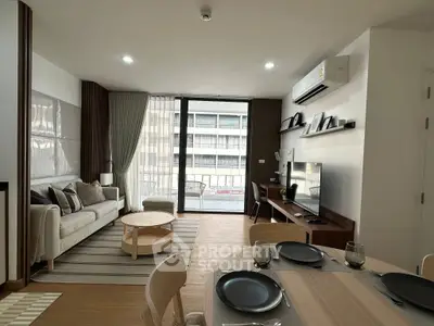 Modern living room with stylish decor and large window offering natural light in a contemporary apartment.