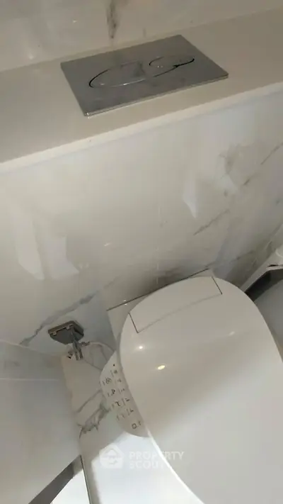 Modern bathroom with sleek toilet and marble wall design