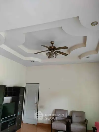 Spacious living room with modern ceiling fan and comfortable seating