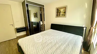 Modern bedroom with sleek black furniture and large mirrored wardrobe