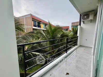 Modern balcony with lush palm tree views in a contemporary apartment complex.