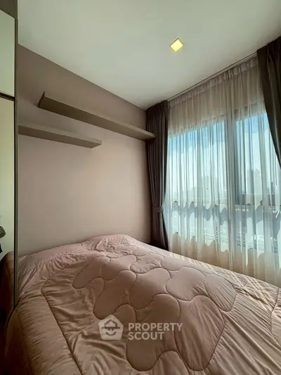 Cozy bedroom with large window and elegant curtains, featuring modern shelving and soft bedding.