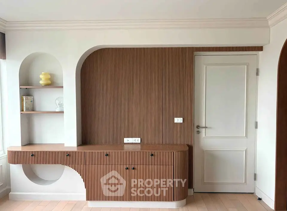 Modern interior with stylish wooden paneling and built-in shelves, showcasing elegant design and functionality.