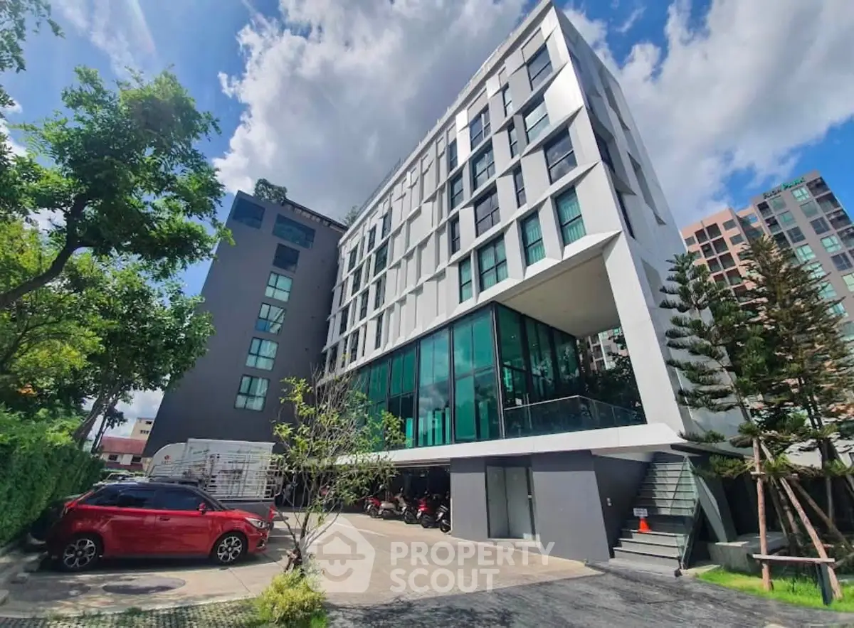 Modern apartment building with sleek design and lush greenery, perfect for urban living.