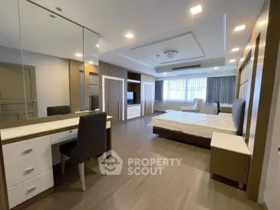 Spacious modern bedroom with elegant furnishings and ample natural light.
