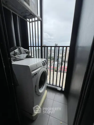 Compact balcony with washing machine and city view, perfect for urban living convenience.