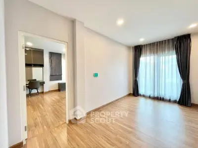 Spacious modern living room with wooden flooring and natural light