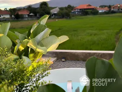 Scenic view of lush green fields from a modern balcony with plants