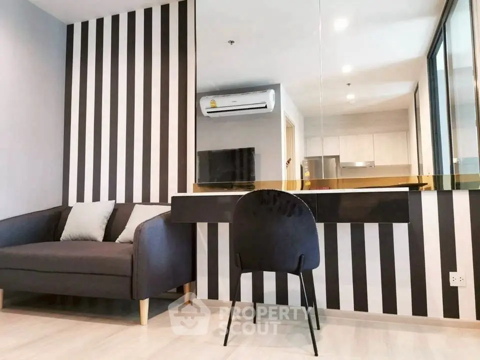 Modern living room with stylish black and white striped wall and cozy seating area.