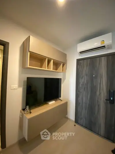 Modern living room with sleek TV unit and air conditioning, perfect for urban living.