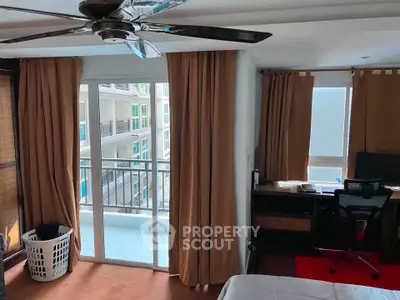 Spacious bedroom with balcony access and modern ceiling fan in a stylish apartment.