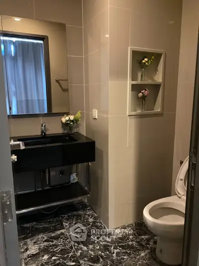 Modern bathroom with sleek black sink and elegant floral decor