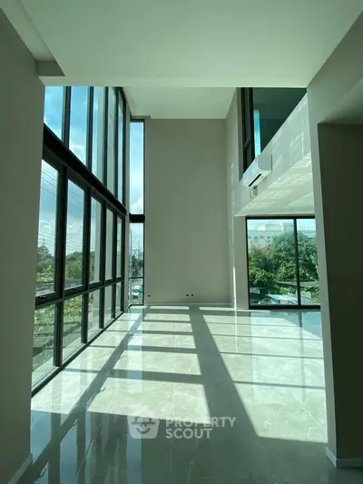 Spacious modern living room with floor-to-ceiling windows and abundant natural light