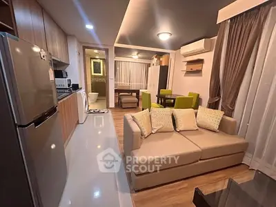 Modern open-plan living room with kitchen, featuring stylish furniture and contemporary design.