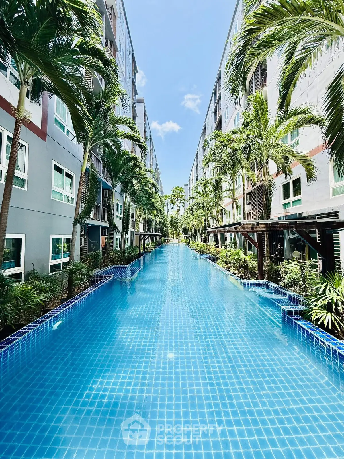 Luxurious apartment complex with stunning central pool and lush greenery