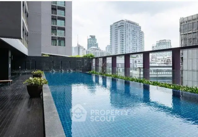 Luxurious rooftop pool with stunning cityscape views in modern high-rise building.