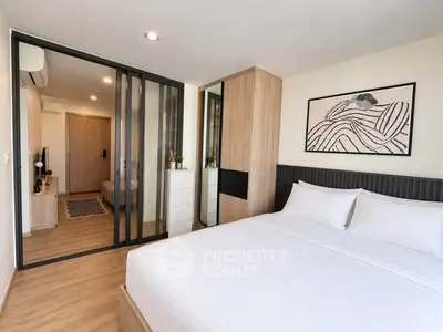 Modern bedroom with stylish decor and sliding glass doors leading to a cozy living area.