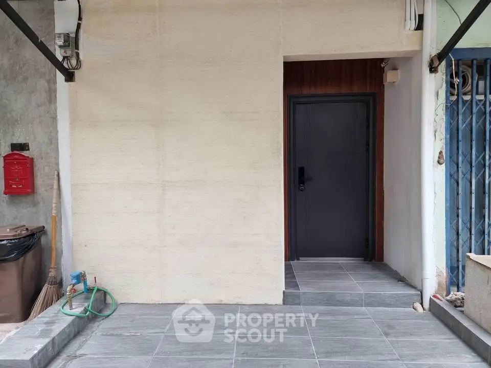 Modern entrance with sleek black door and tiled flooring