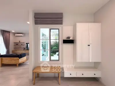 Modern living room with stylish furniture and large window overlooking garden.