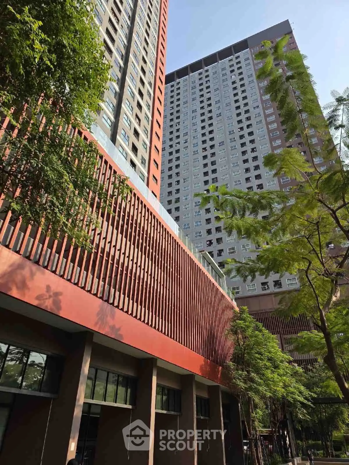 Modern high-rise building with lush greenery and contemporary design.