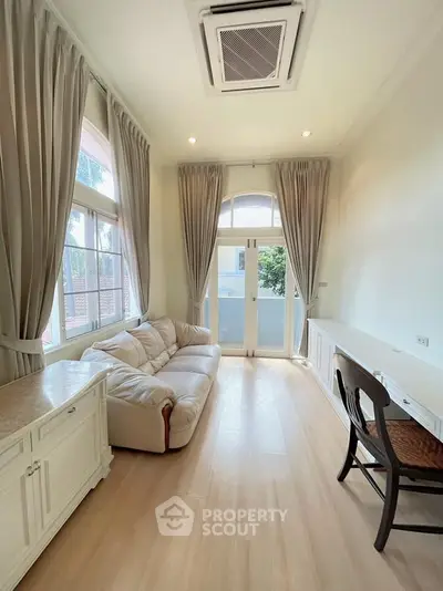 Elegant living room with high ceilings, large windows, and stylish furniture, perfect for modern living.
