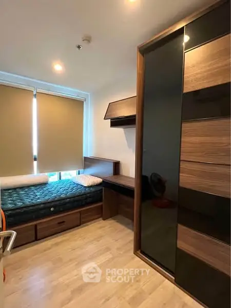 Cozy bedroom with modern furniture and ample natural light, perfect for relaxation.