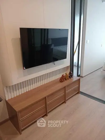 Modern living room with wall-mounted TV and sleek wooden cabinet
