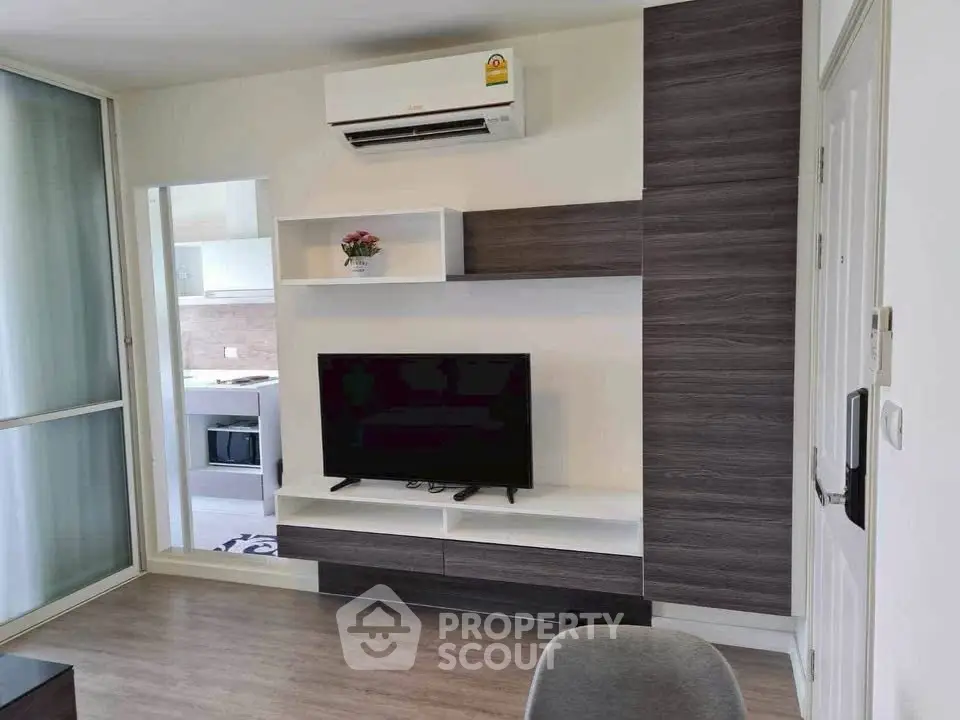 Modern living room with sleek TV unit and air conditioning, showcasing contemporary design.