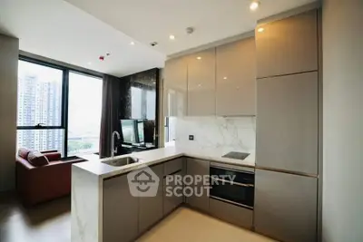 Modern kitchen with sleek cabinetry and open layout in high-rise apartment