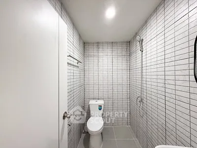 Modern minimalist bathroom with sleek tile design and contemporary fixtures.