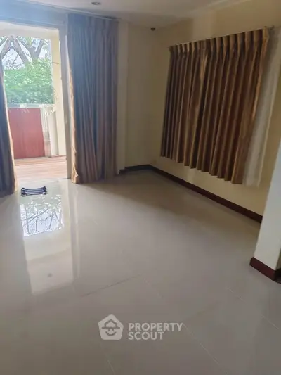 Spacious empty room with large windows and balcony access, perfect for customization.