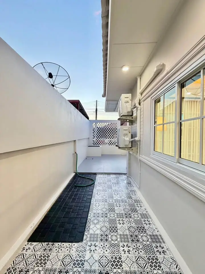 Charming outdoor area with patterned tiles and modern amenities, perfect for relaxation and utility.