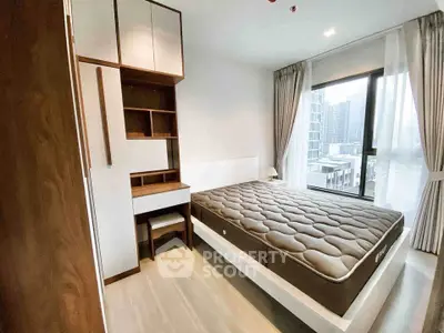 Modern bedroom with large window and stylish furniture in urban apartment