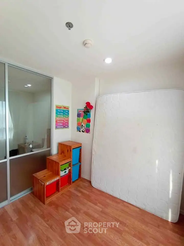 Bright room with wooden floor, glass partition, and colorful storage bins