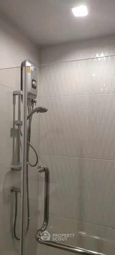 Modern bathroom shower with sleek design and safety rail in contemporary home.