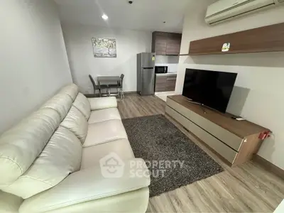 Modern living room with sleek furniture and open kitchen layout in a stylish apartment.