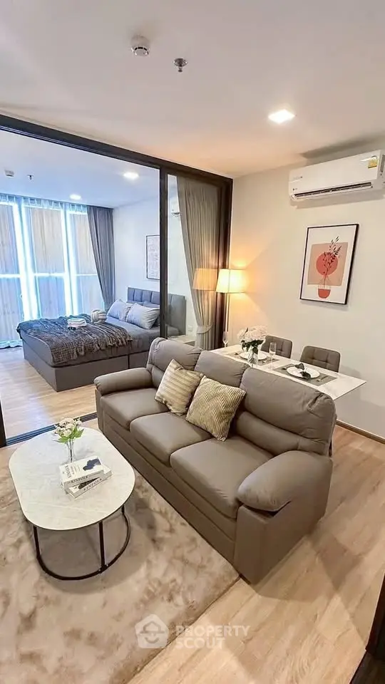 Modern open-plan living room with cozy sofa and stylish bedroom in a chic apartment.