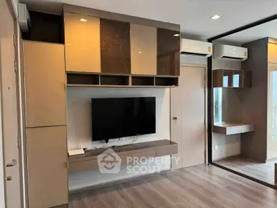 Modern living room with sleek built-in TV unit and mirrored wall in stylish apartment.