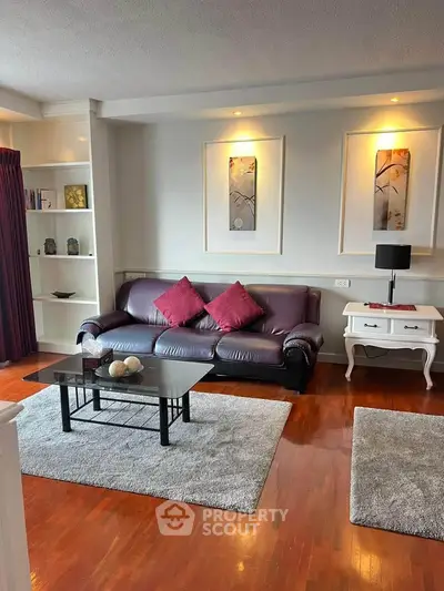 Elegant living room with leather sofa, modern decor, and hardwood floors in a stylish apartment.