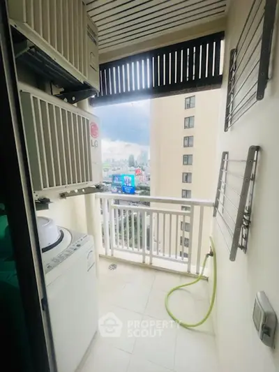 Compact balcony with washing machine and city view, ideal for urban living.