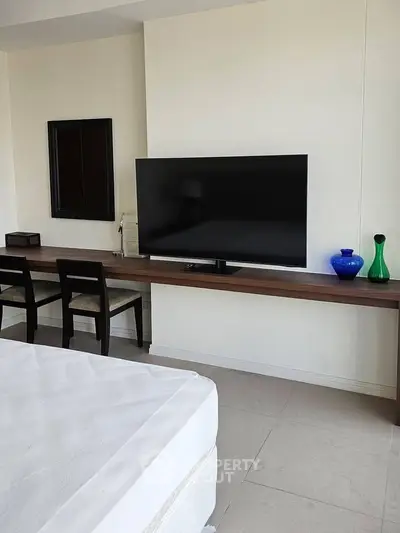 Modern bedroom with sleek TV setup and minimalist decor