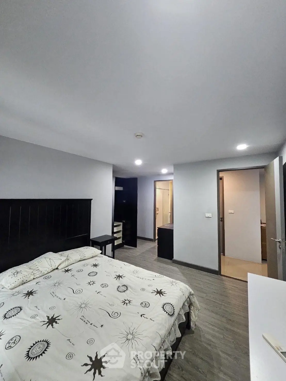 Spacious bedroom with modern decor and stylish bedding in a contemporary apartment.