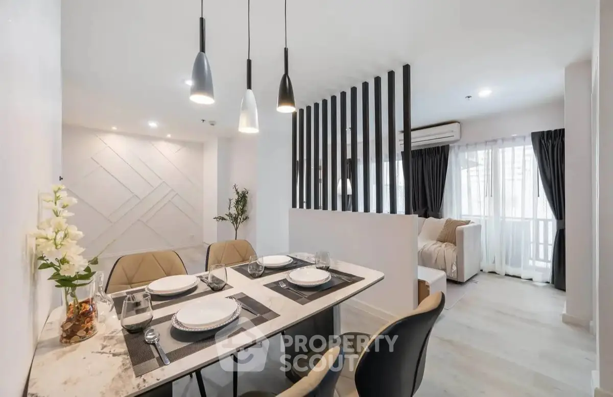 Modern open-plan dining and living area with stylish decor and natural light.