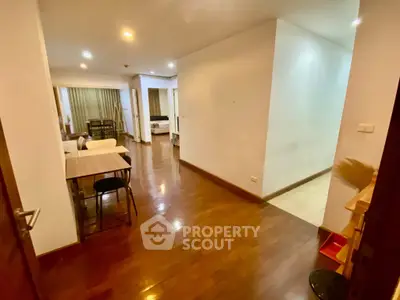 Spacious open-plan living area with wooden flooring and modern lighting.