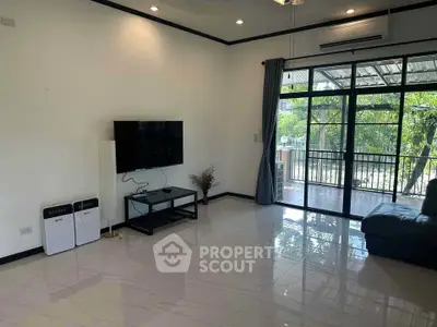 Spacious living room with modern decor and large windows overlooking a lush garden.
