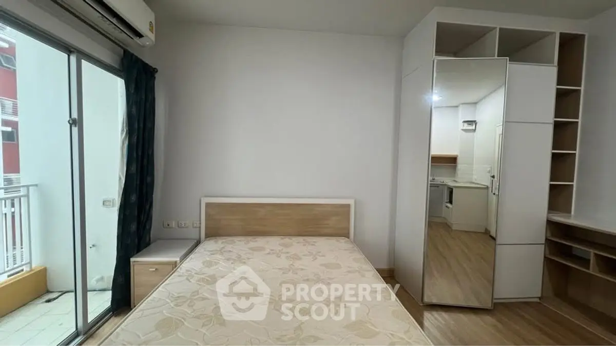 Modern bedroom with balcony access and built-in storage in a stylish apartment.