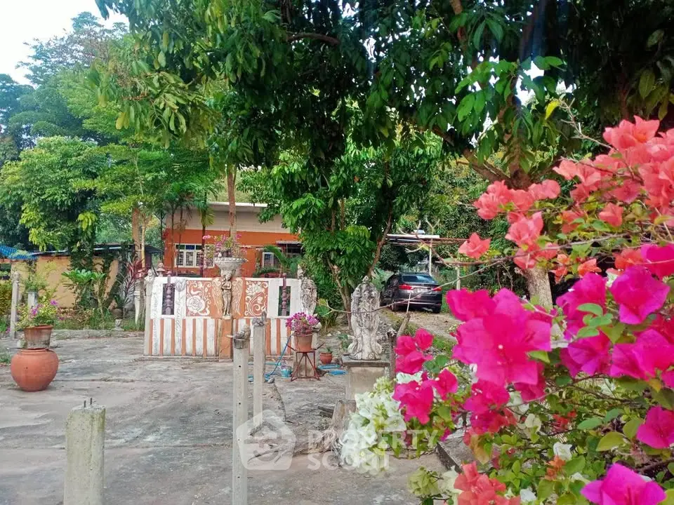 Charming garden view with vibrant flowers and cozy house in the background, perfect for nature lovers.